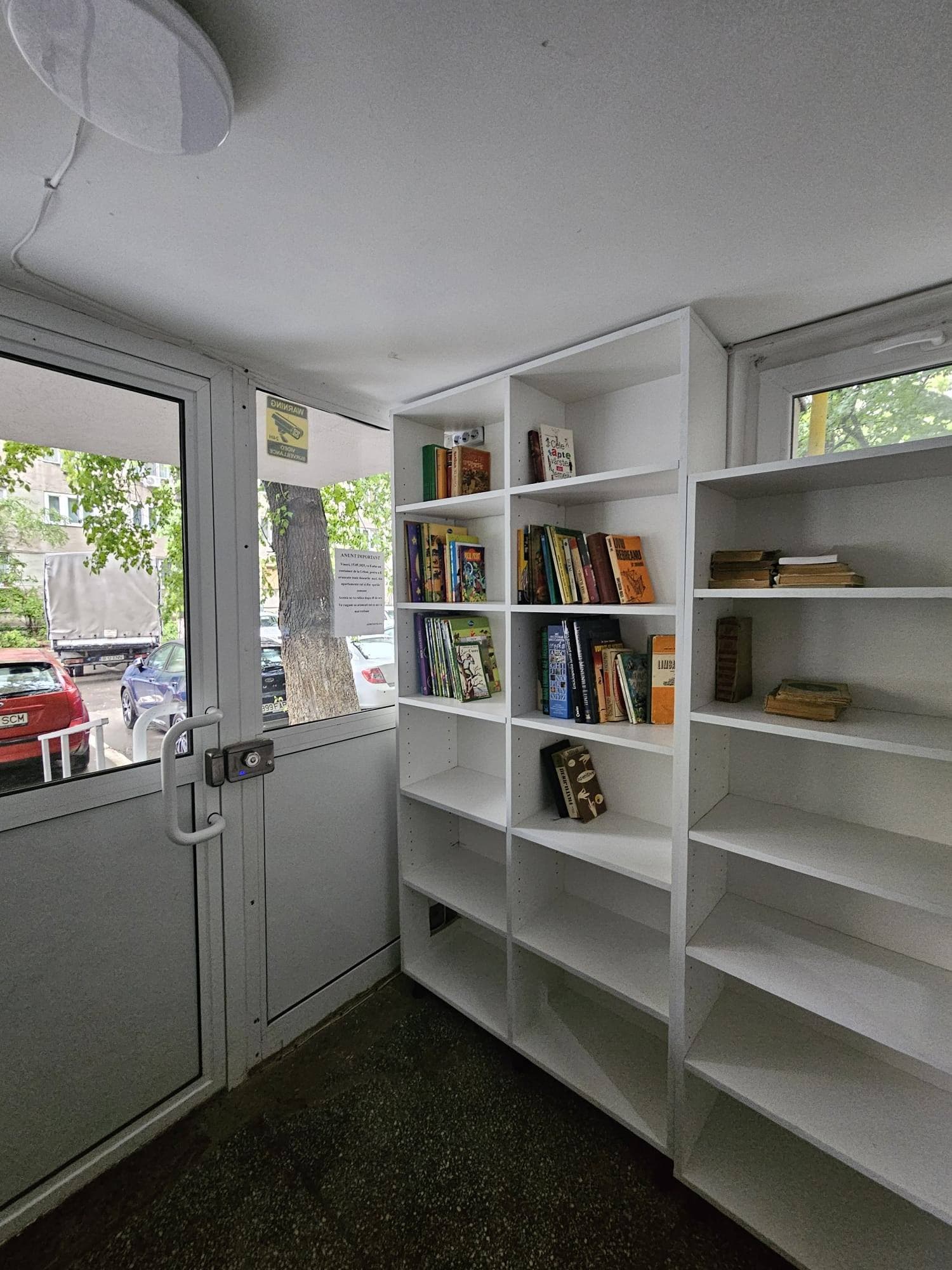 FOTO | O bucureșteancă a improvizat o bibliotecă într-o scară de bloc din Sectorul 6. E „sponsorizată” de toți cei care au cărți de dat, iar iubitorii de lectură sunt invitați să împrumute și să citească