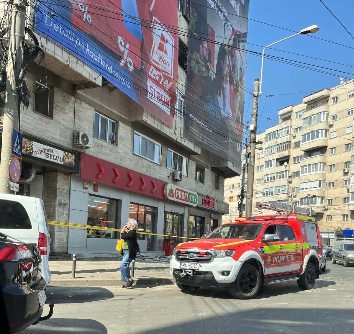 Mesh publicitar desprins de pe faţada unui bloc din Timişoara, cu tot cu plăcile de beton care au cedat, ajungând pe trotuar / Fritz: Cineva a dat găuri / Cineva putea fi acolo în acel moment / Firma mai fusese amendată - FOTO